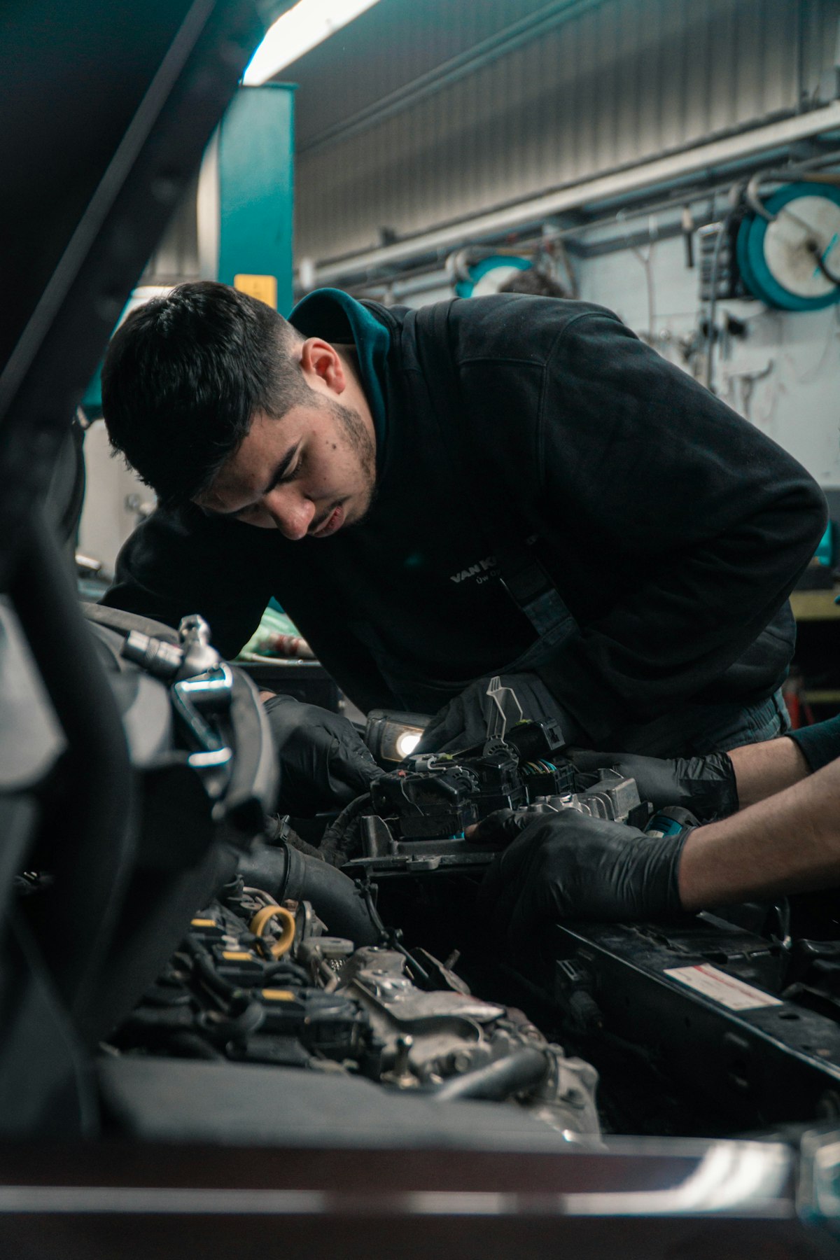 An AC Delco London technician performing mechanical service under the hood